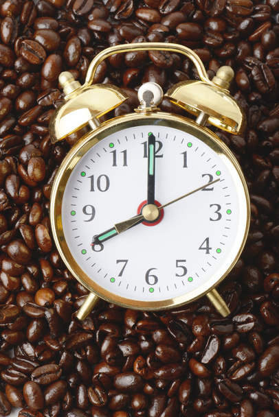 a clock on a bed of coffee beans - Photo, image