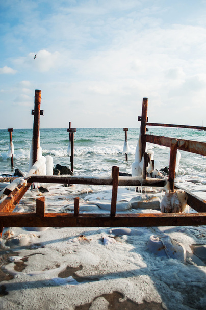 Mar de invierno congelado con poste de madera. Vertical
 - Foto, Imagen