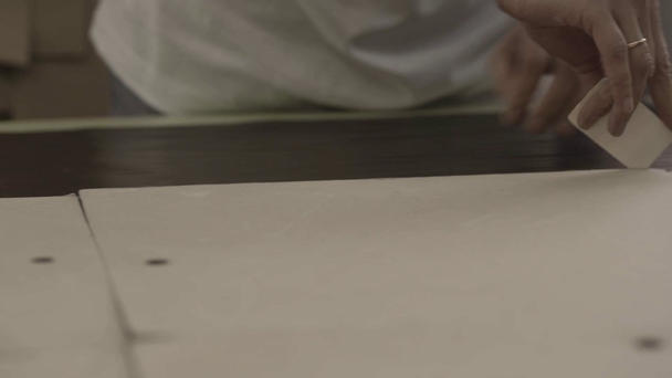 Рабочий окружает картон куском мела на мебельной фабрике
 - Кадры, видео