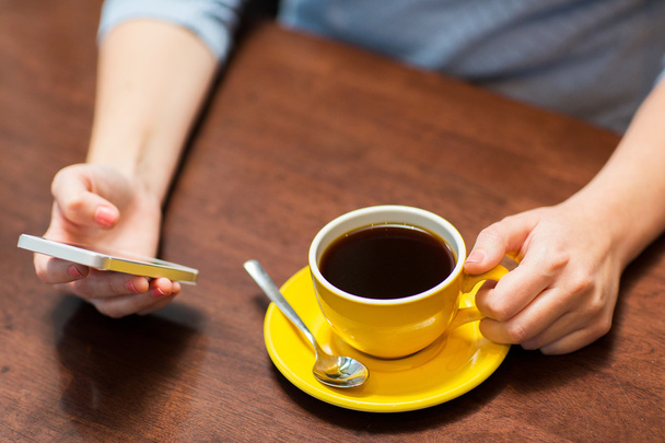 close up of woman with smartphone and coffee - Foto, afbeelding