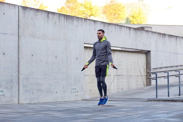man exercising with jump-rope outdoors - 写真・画像