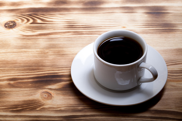 Coffee in cup on light wooden table - Fotó, kép