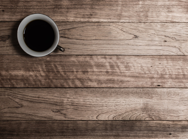 Cup of coffee on wooden table - Foto, afbeelding