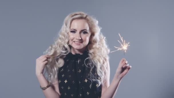 Closeup beauty portrait of young girl holding sparklers over grey background. - Séquence, vidéo