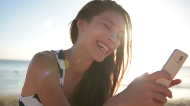 smiling woman looking at smartphone - Materiał filmowy, wideo