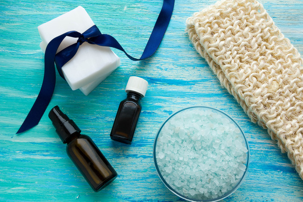 bouteilles de savon bio naturel huile essentielle et sel de mer loofah bio sur une table en bois bleu
 - Photo, image