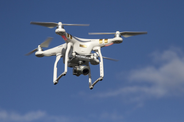 青い空を飛んでいるカメラと小型無人ヘリコプター - 写真・画像
