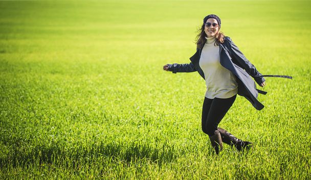 Woman with backpack walking in green field - Foto, Bild
