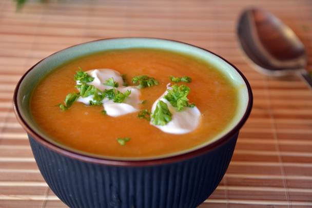Romige Butternut Squash soep In keramische kom op een tafel - Foto, afbeelding