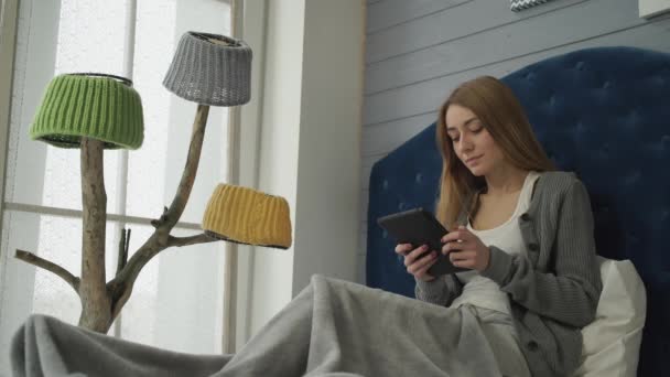 Mujer sentada en una cama con una tableta
. - Metraje, vídeo