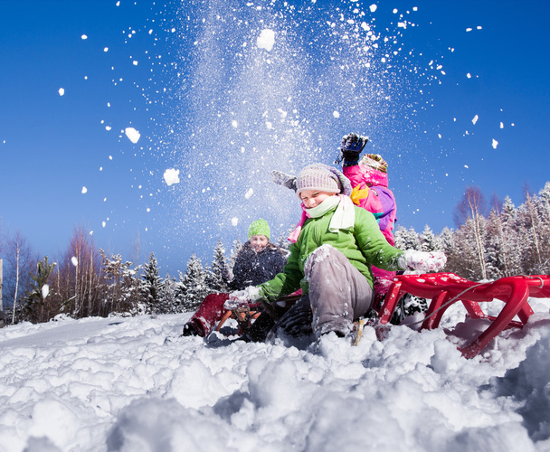 Счастливые дети катаются на санках зимой. Группа детей, проводящих хорошо время зимой. - Фото, изображение