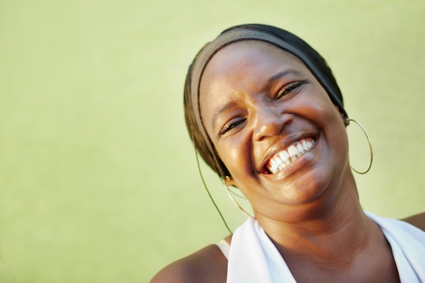 Musta nainen valkoinen paita hymyilee kameralle
 - Valokuva, kuva