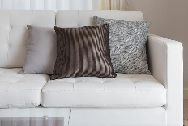 modern white sofa with brown pillows - 写真・画像