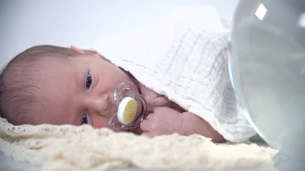 Baby lying next to fish bowl - Footage, Video