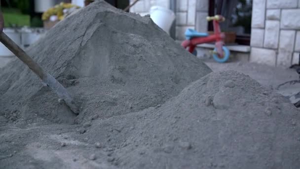 mannen zijn schept kalk en zand op de binnenplaats - Video