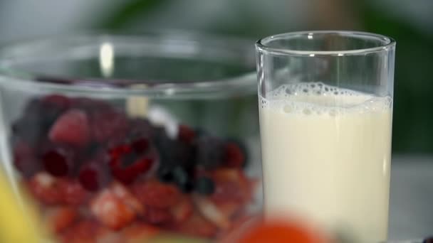 milk near bowl full of delicious fruits - Záběry, video