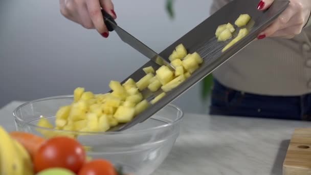 Woman moving the pineapple into a bowl - Séquence, vidéo