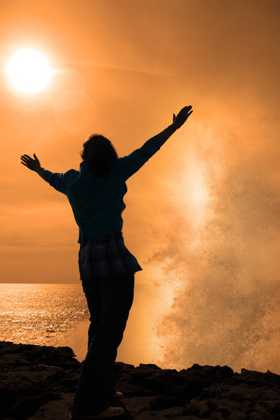 Силует самотньої жінки, що стикається з потужною хвилею на сонці
 - Фото, зображення
