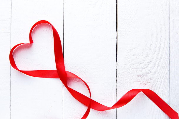 Heart shape red ribbon on white table. - Foto, Imagen