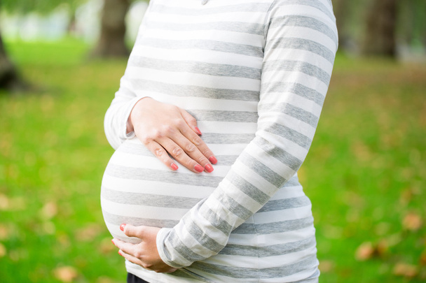 Szczęśliwy i młoda kobieta w ciąży w parku w lecie - Zdjęcie, obraz