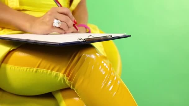 Γυναίκα παίρνει σημειώσεις σχετικά με το γόνατό - Πλάνα, βίντεο