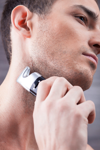 Handsome young guy with special shaver - Photo, image