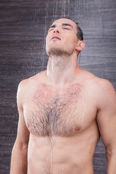 Cheerful male athlete is washing himself - Φωτογραφία, εικόνα