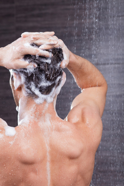 Handsome fit guy is cleaning his head - Foto, Imagen