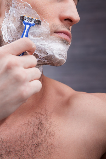 Cheerful young guy shaves his stubble - Foto, Imagem
