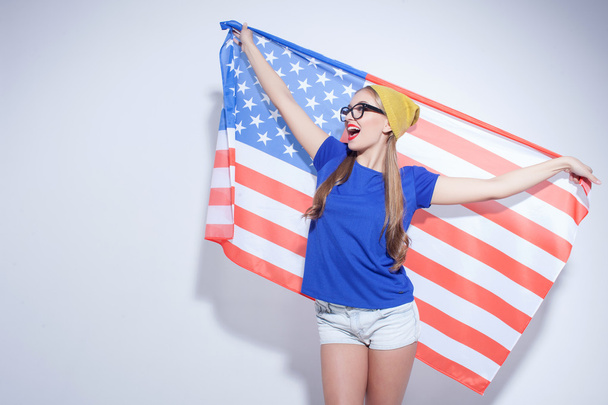 Cheerful young woman is expressing her patriotism - 写真・画像