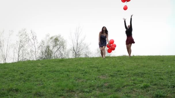 kaksi naista juoksemassa ilmapallojen kanssa
 - Materiaali, video