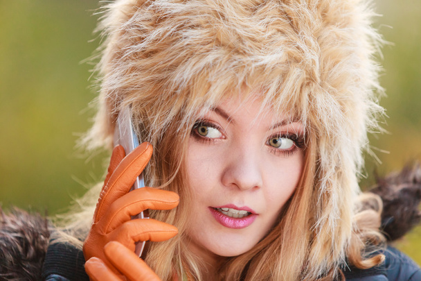 Pretty woman in fur hat talking on mobile phone. - Fotó, kép