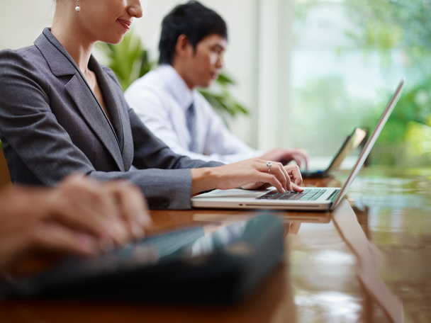 Hombres y mujeres de negocios escribiendo en la PC durante la reunión
 - Foto, Imagen