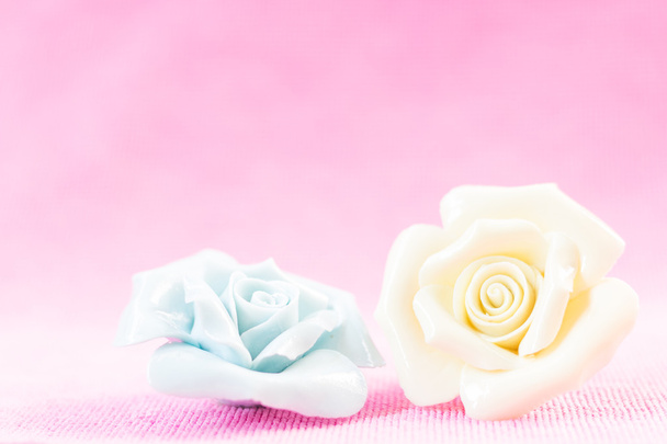 Pastel Rose (keramiek) op roze fabic achtergrond - Foto, afbeelding