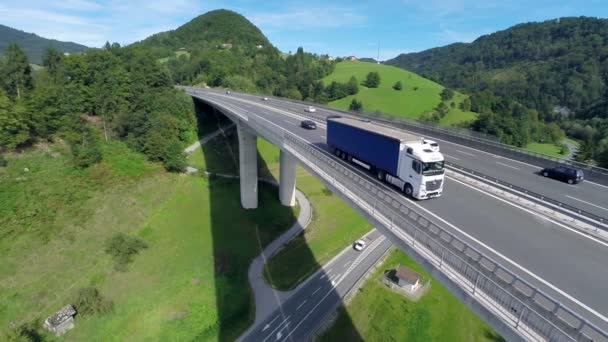 Grote vrachtwagen die de camera op een brug passeert - Video