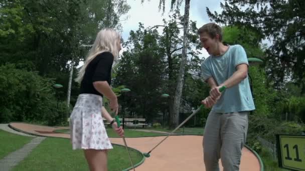 пара, играющая в мини гольф
 - Кадры, видео