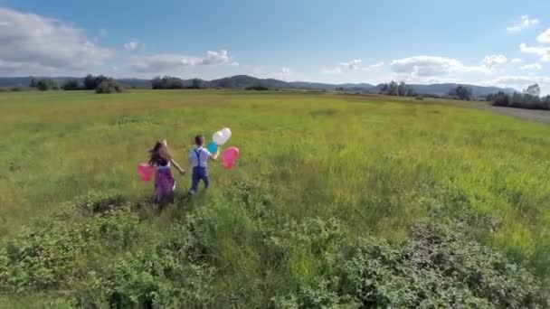 Δύο παιδιά που τρέχουν με μπαλόνια - Πλάνα, βίντεο