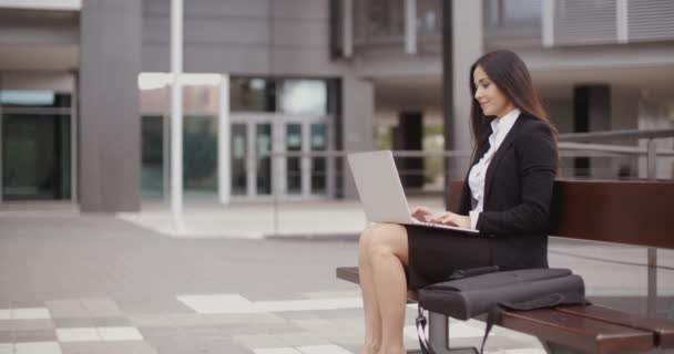 zakenvrouw die op laptop op Bank buitenshuis werkt - Video
