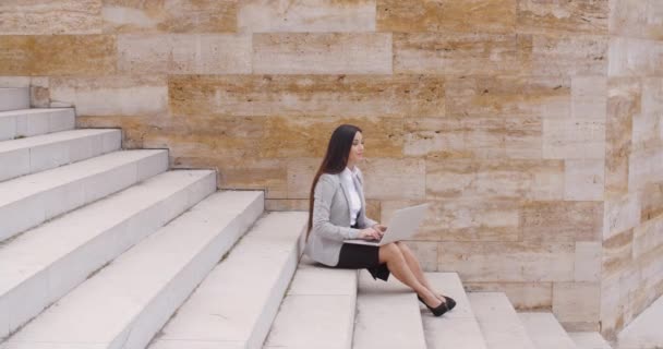 zakenvrouw zittend op de marmeren trap met laptop - Video