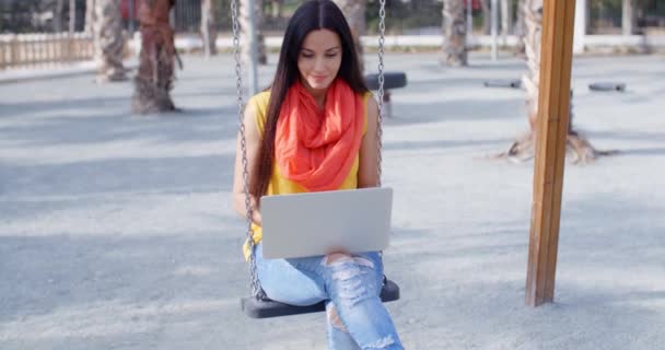 žena sedí na houpačce a pracují na notebooku - Záběry, video