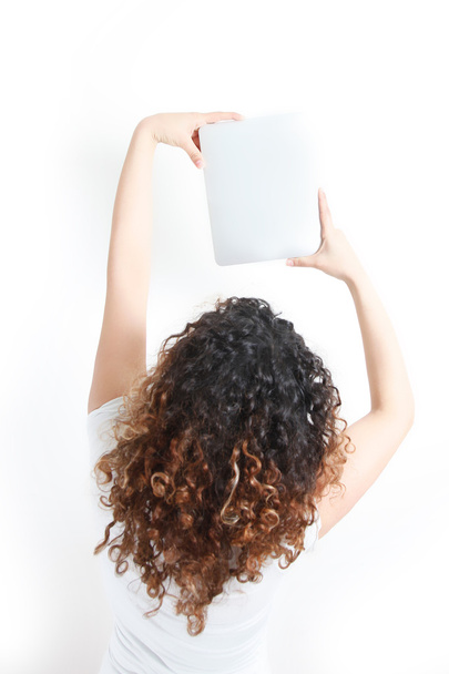 jonge vrouw met tablet PC omhoog op de muur - achteraanzicht - whi - Foto, afbeelding