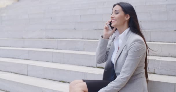 businesswoman on marble stairs talking on phone - Video