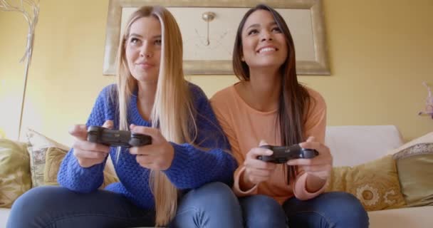 kobiety, grając w gry wideo na kanapie - Materiał filmowy, wideo
