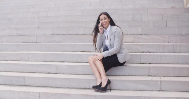 businesswoman on marble stairs talking on phone - Video
