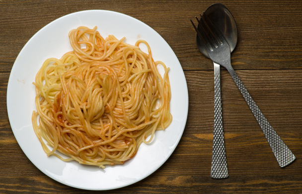 spaghetti on a plate on a wooden background - 写真・画像