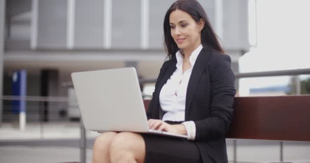 mujer de negocios que trabaja en el ordenador portátil en el banco al aire libre
 - Imágenes, Vídeo