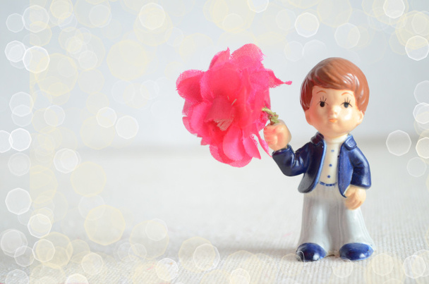 Cartão de saudação Valentine com estatueta menino romântico com buquê de flores
 - Foto, Imagem
