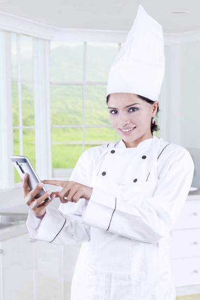 Chef using cellphone in the kitchen - Zdjęcie, obraz
