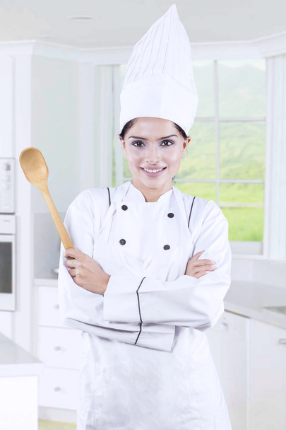 Housewife wearing chef uniform in the kitchen - Фото, зображення