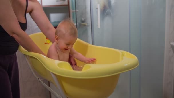 Happy small child in a plastic bathtub - Video
